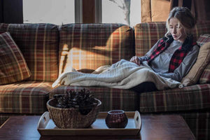 Woman sitting on the couch with a blanket